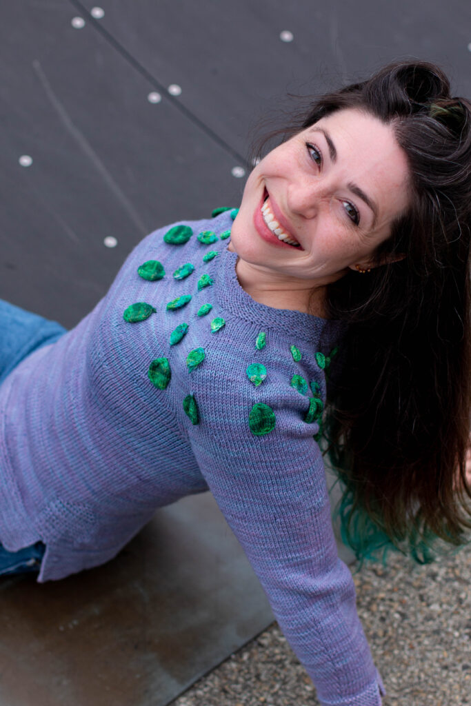 Woman smiles at the camera wearing the Circle Dance Sweater 